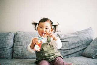 子供が飲み物持って笑っている画像